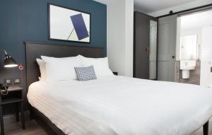 伦敦Residence Inn by Marriott London Tower Bridge的一间带白色大床的卧室和一间浴室