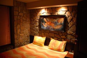 旧扎戈拉托多罗维奇盖斯特豪斯旅馆的一间卧室设有石墙、一张床和一幅画