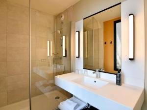 圣纳泽尔ibis Styles Saint Nazaire Centre Gare的一间带水槽、镜子和淋浴的浴室