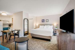 SorrentoSonesta ES Suites San Diego - Sorrento Mesa的酒店客房设有一张大床和一个厨房。