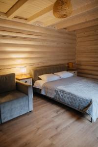 米库利钦Vila Mila的一间卧室配有一张床和一张沙发