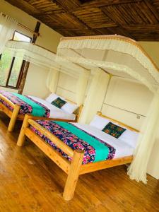 BuhomaBwindi Neckview Lodge的一间卧室,配有两张床