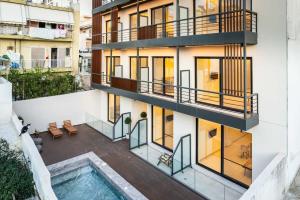 雅典Athens Grec Suites - The Ultimate City Getaways In Dafni的公寓大楼设有游泳池和阳台