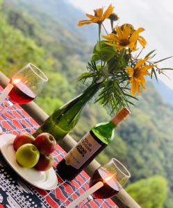 BuhomaBwindi Neckview Lodge的一瓶葡萄酒和花瓶