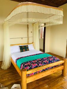 BuhomaBwindi Neckview Lodge的一间卧室配有一张木床和天篷