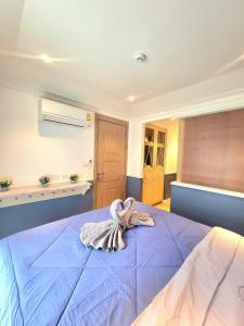纳仲天Seven Seas Cote D'azur Resort Jomtien的一间卧室配有一张蓝色的床,上面有毛巾