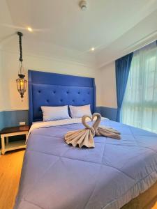 纳仲天Seven Seas Cote D'azur Resort Jomtien的一张大蓝色的床,上面有毛巾