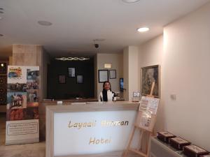 安曼Layaali Amman Hotel的坐在酒店柜台上的女人