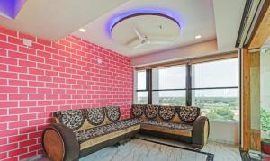 艾哈迈达巴德Hotel Shree Regency Ahmedabad的一间设有沙发的粉红色砖墙客房