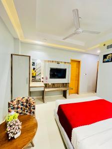新德里Hotel NASHA Unit By Worth New Delhi的一间卧室配有一张床、一张桌子和一台电视。