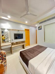 新德里Hotel NASHA Unit By Worth New Delhi的一间卧室配有一张床和一台平面电视