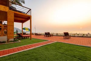 阿贡达The O2H Agonda Beach Resort的一个带桌椅的庭院和海滩