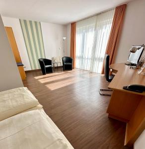 沃尔姆斯阿斯伽德酒店的酒店客房带一张床、一张桌子和椅子