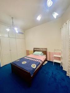 迪拜Salahuddin Metro Home Stay的一间卧室配有一张蓝色地毯的床
