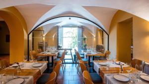 圣胡安-德拉斯阿巴德萨斯Abbatissa Hotel Restaurant的餐厅设有桌椅和大窗户。