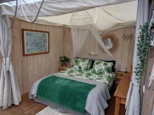 HankVrijstaande accommodatie Glamping de Kas InN的一间卧室配有一张带天蓬的床