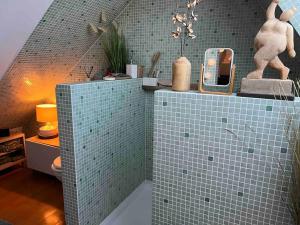 Dion-le-MontMaison cosy的浴室设有蓝色瓷砖墙和镜子
