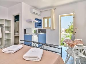 纳乌萨Villa Maria - Naoussa Squares Blue & Gold Suite的客房设有厨房和带毛巾的桌子。