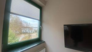 姆拉哥沃Pokoje na Cyplu的配有绿色框架的窗户和平面电视