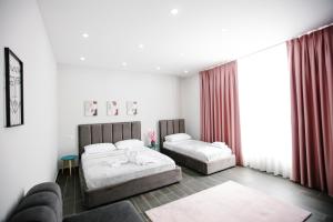 都拉斯Andor Luxury Hotel的一间带两张床和一张沙发的卧室