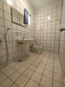 马公澎湖乐悠悠民宿的瓷砖浴室设有卫生间和水槽