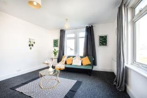 史云顿A cosy 2 bed flat in Swindon的客厅设有绿色沙发和窗户。