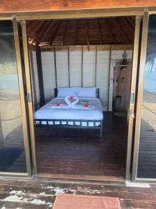 俊穆岛Sunset Beach Bungalow Koh Pu的一个带床罩的门廊内的一张床位