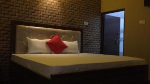 阿格拉Divine sparrow family homestay的一间卧室配有一张带两个红色枕头的床