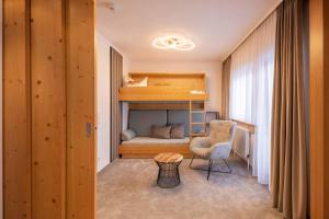 富尔普梅斯法米莉安奥恩霍夫维塔酒店的小房间设有双层床和椅子