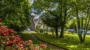 戴斯Pinehurst Lodge Hotel - Aberdeen的穿过树木和鲜花的公园的路径