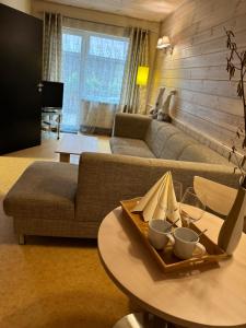 Ozolnieki阿加特酒店的客厅配有沙发和带酒杯的桌子