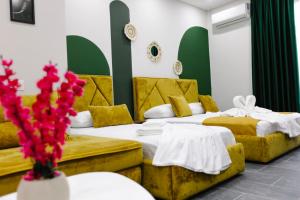 都拉斯Andor Luxury Hotel的红色鲜花酒店客房内的两张床