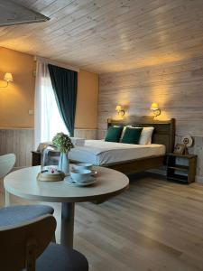 Ozolnieki阿加特酒店的一间卧室配有一张床和一张带茶几的桌子