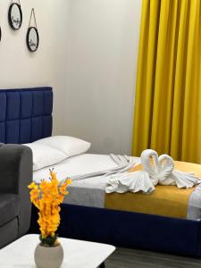 都拉斯Andor Luxury Hotel的客房设有床、沙发和桌子。