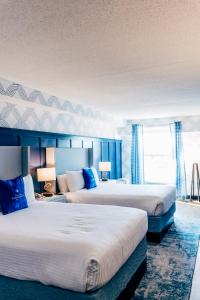 塞伦塞勒姆海滨酒店及套房的两张位于酒店客房的床,拥有蓝色的墙壁