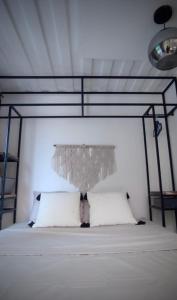 Santa María MizataCASA V - Mizata的卧室配有带金属华盖的白色床