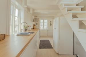 托尔斯港Charming Retreat in the Heart of Tórshavn的一间厨房,配有白色橱柜和楼梯