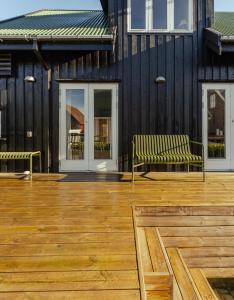 托尔斯港Charming Retreat in the Heart of Tórshavn的木甲板上的两把长椅,有楼