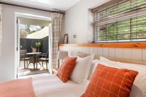 牛顿阿伯特比克利穆尔酒店的一间卧室配有带橙色和白色枕头的床