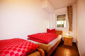 伦讷施塔特Ferienhof Verse Ferienwohnung Kornkammer的一间卧室配有两个红色枕头和窗户