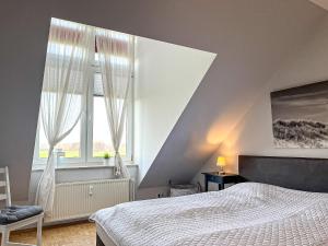 博尔滕哈根Sünnslag Ostsee-Perle Wohnung 044的一间卧室设有一张床和一个大窗户