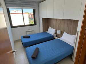 克尤伯厄拉斯Ático en Cubelles playa的酒店客房设有两张床和窗户。