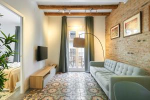 巴塞罗那64 Apartment in a typical Barcelona's old building的带沙发和砖墙的客厅