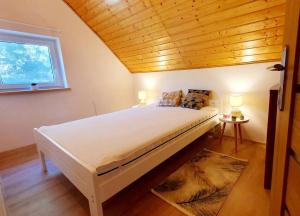 Całoroczny domek nad Jeziorem Piaseczno的一间卧室设有一张带木制天花板的大床