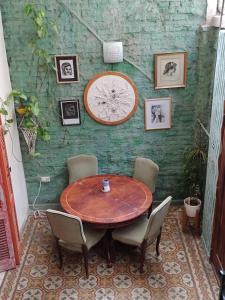 布宜诺斯艾利斯La Risa de la Medusa的一张带椅子的木桌和墙上的时钟