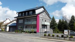 腓特烈港Hotel Gästehaus Stock的街道边的粉红色和黑色建筑