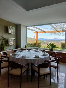 维塞乌Quinta de Marzovelos的一间带桌椅和大窗户的用餐室