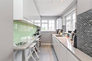 伦敦£4 Million Covent Garden Apartment的厨房配有白色橱柜和台面