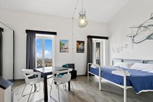 热那亚Ostello Bello Genova的卧室配有一张床和一张桌子及椅子