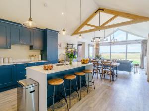 东伊尔斯利1 Pheasant的一间设有蓝色橱柜的厨房和一个带凳子的厨房岛